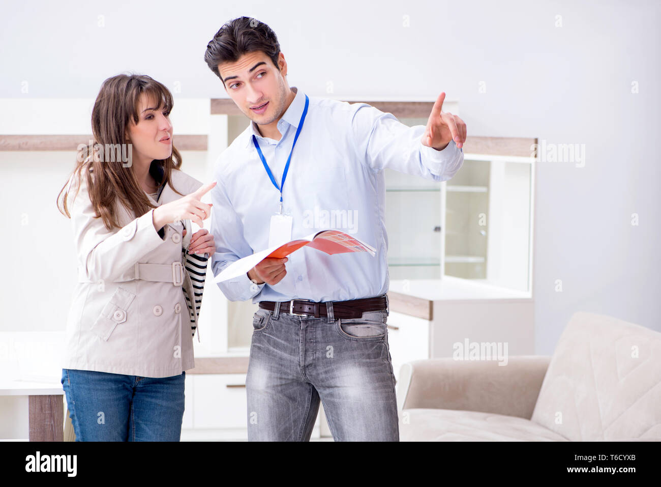 Salesman explaining to woman customer at furniture store Stock Photo ...