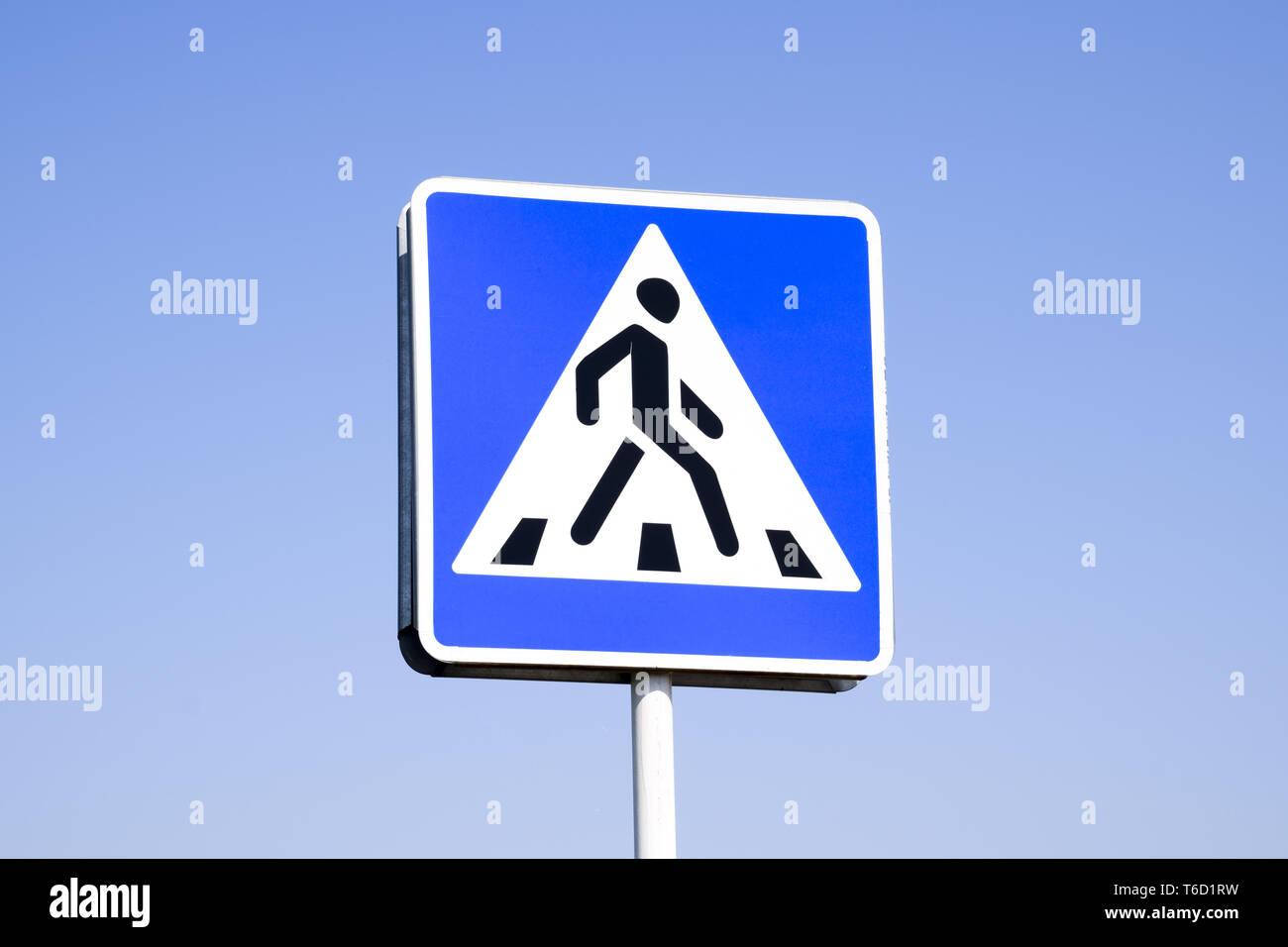 A pedestrian crossing sign. Sign on a blue sky background. Stock Photo