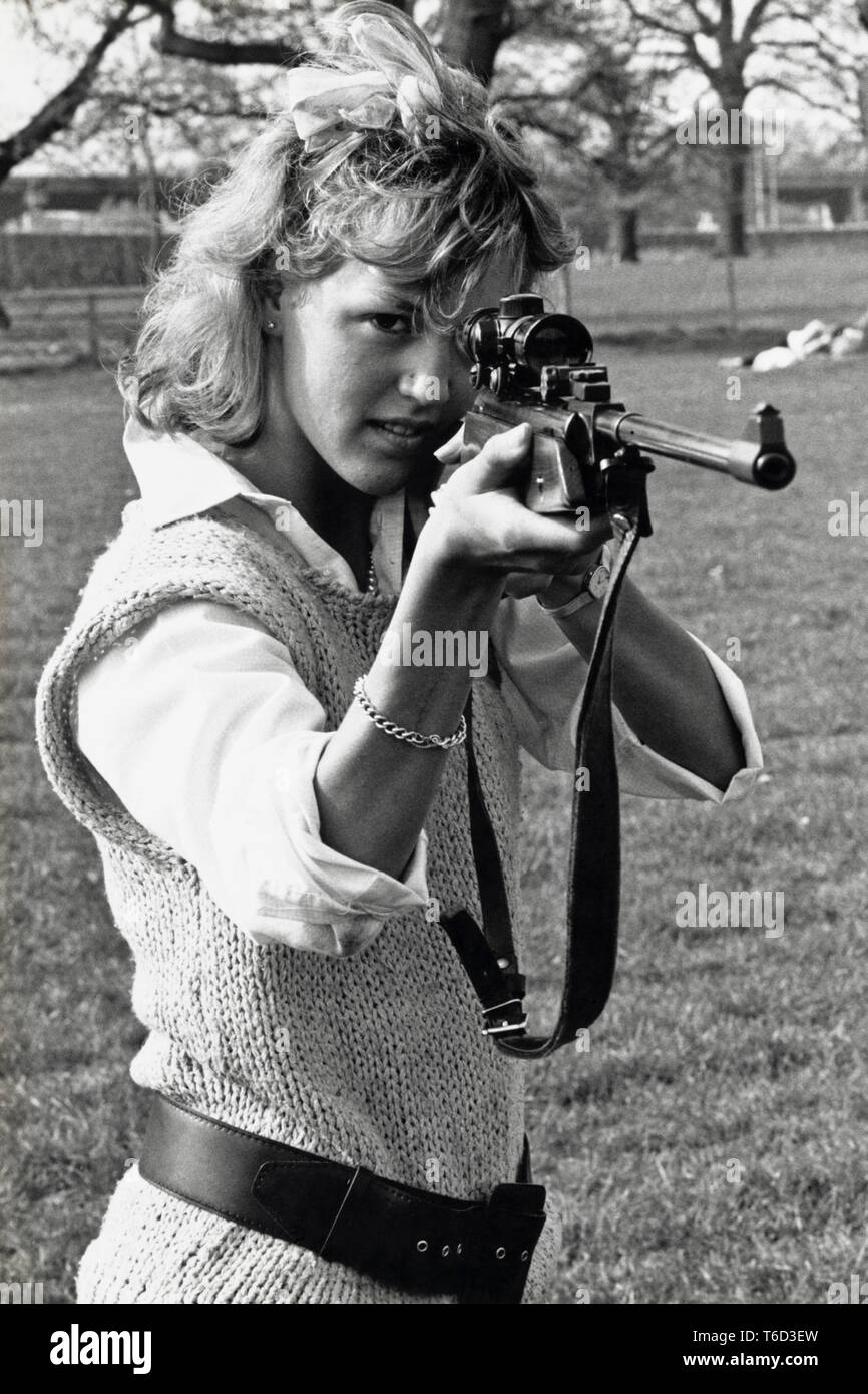 Young woman shooting air rifle at target in field Newport South Wales UK Stock Photo
