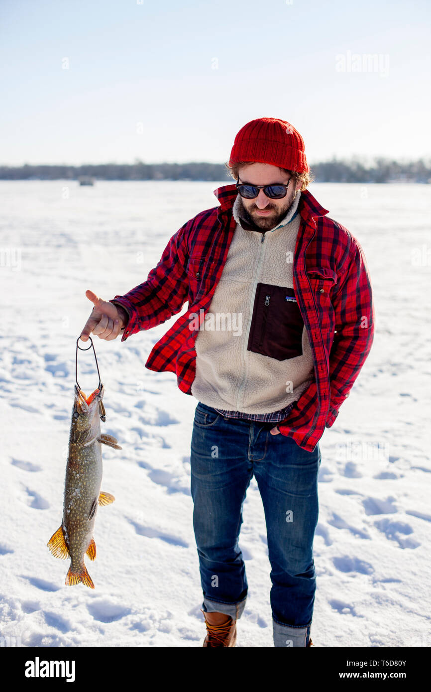Fisherman holding northern pike hi-res stock photography and