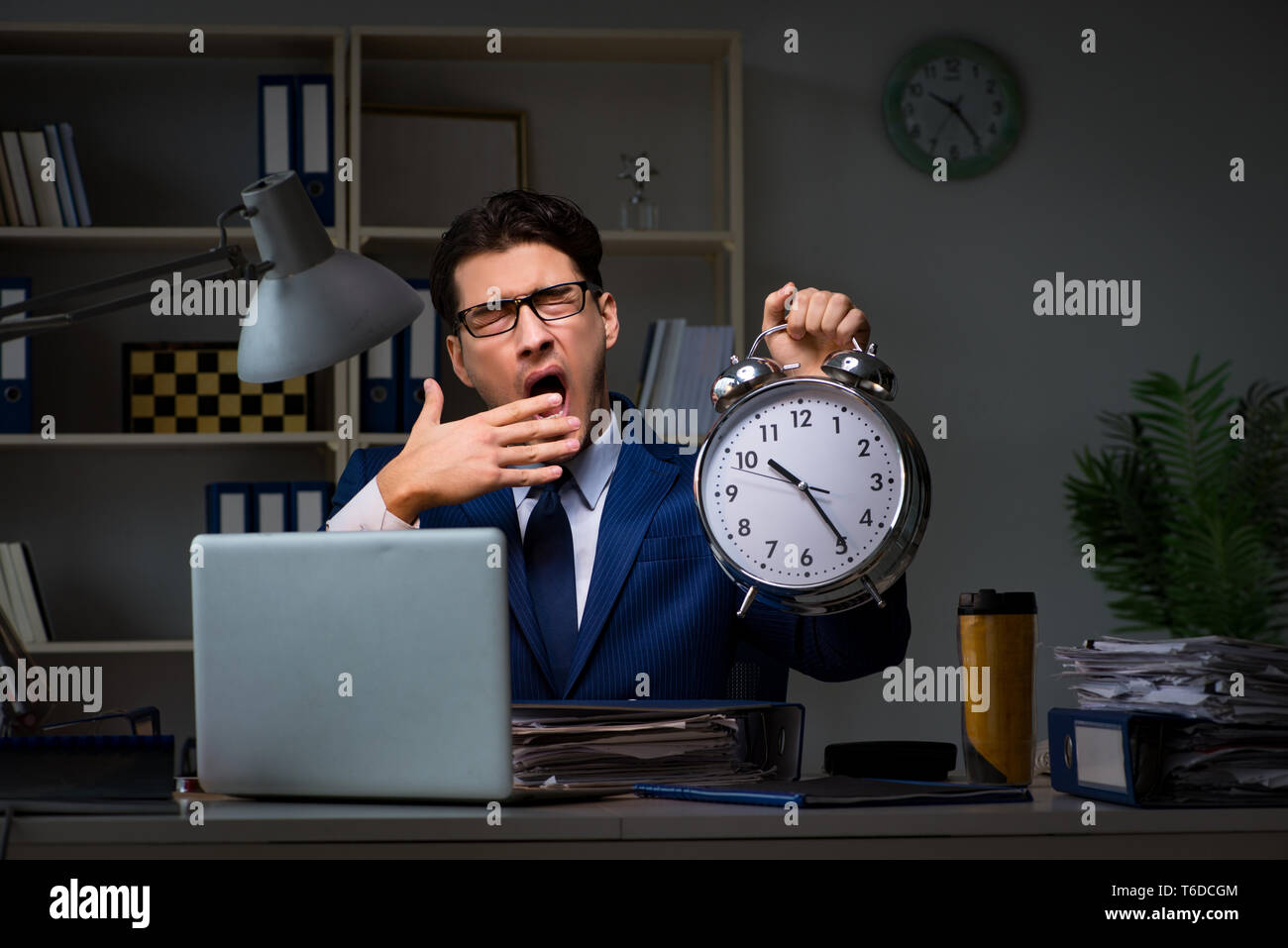 Businessman falling asleep during long hours in office Stock Photo
