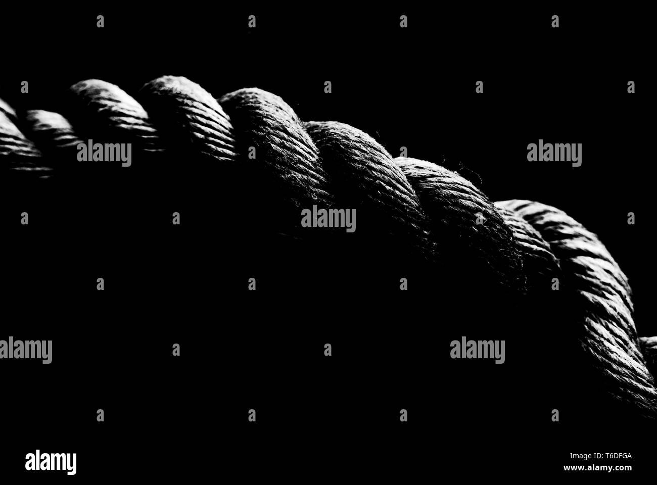 Rope from a sailing boat, black and white at high contrast, low key style, close-up. Shallow depth of field. SDF Stock Photo