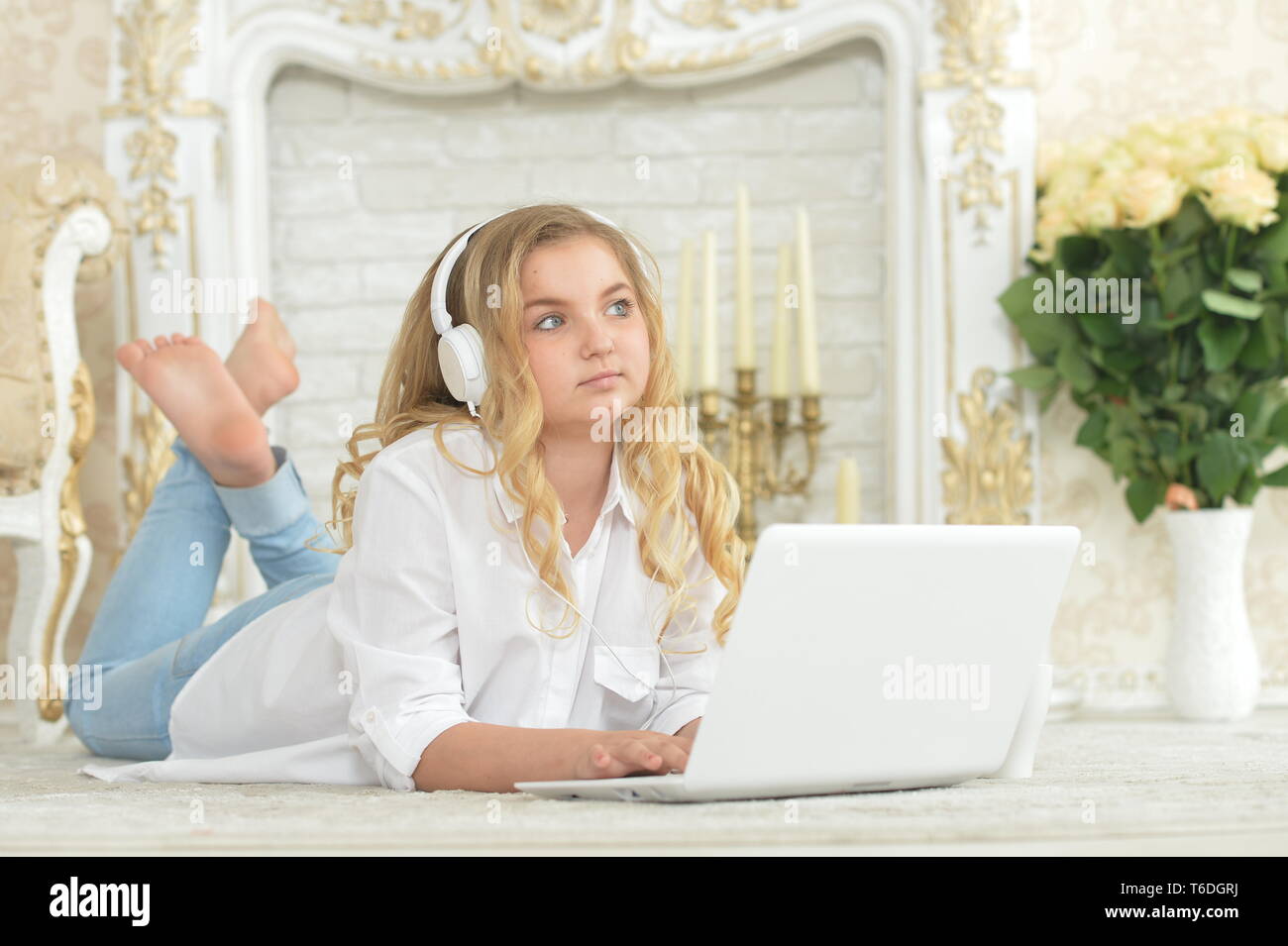 Teenage girl in headphones lying on floor Stock Photo - Alamy