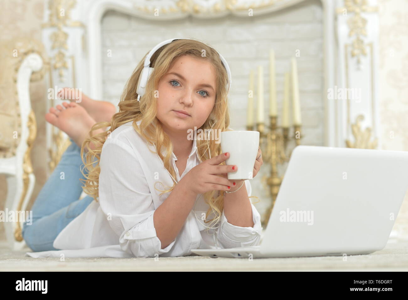 Teenage girl in headphones lying on floor Stock Photo - Alamy