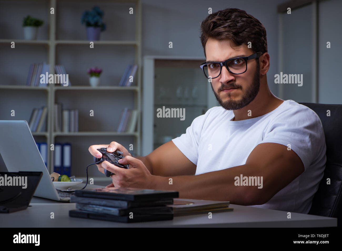 Young man playing games long hours late in the office Stock Photo Alamy