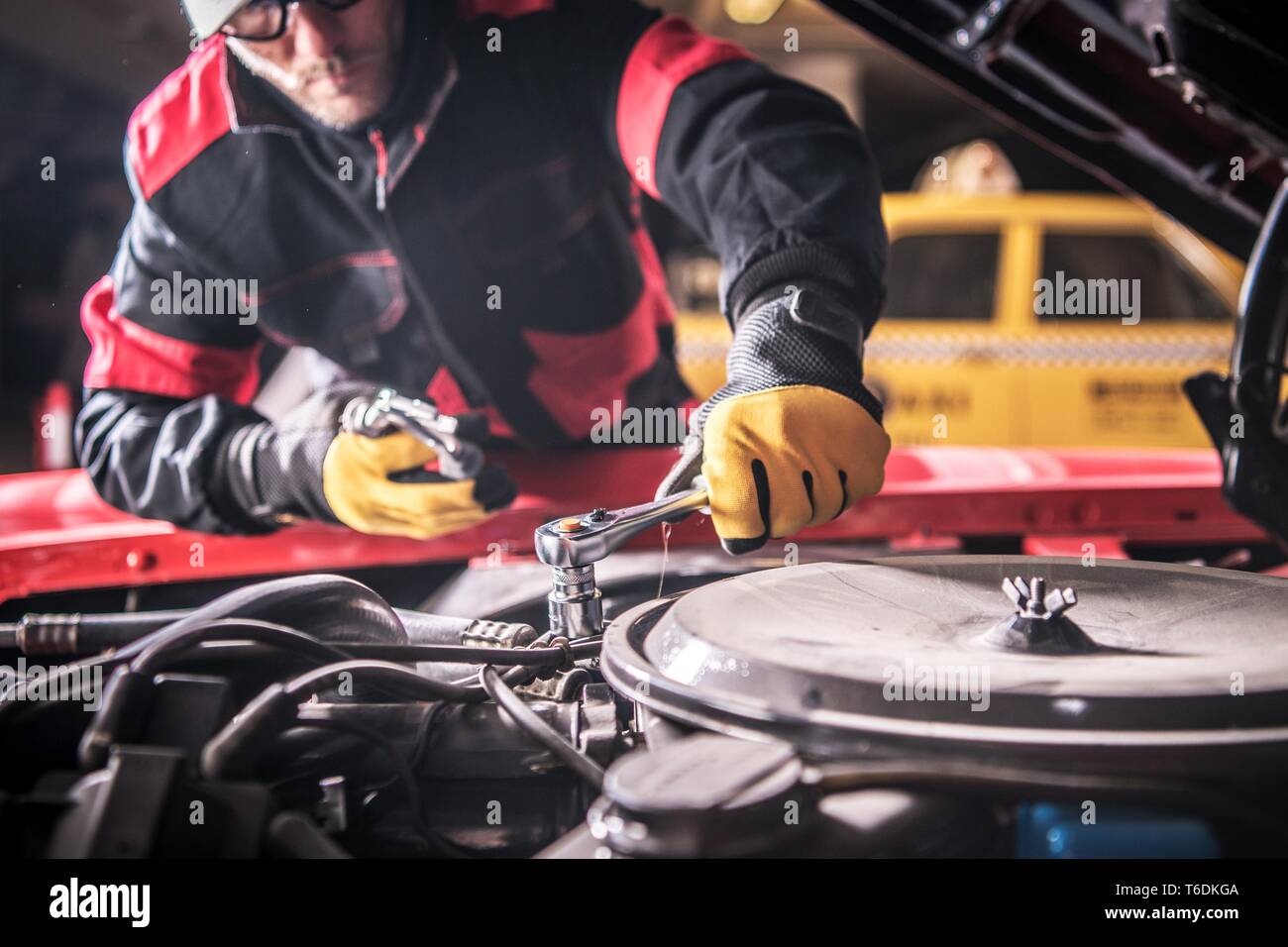 Caucasian Car Mechanic in His 30s Repairing Aged Gasoline Engine