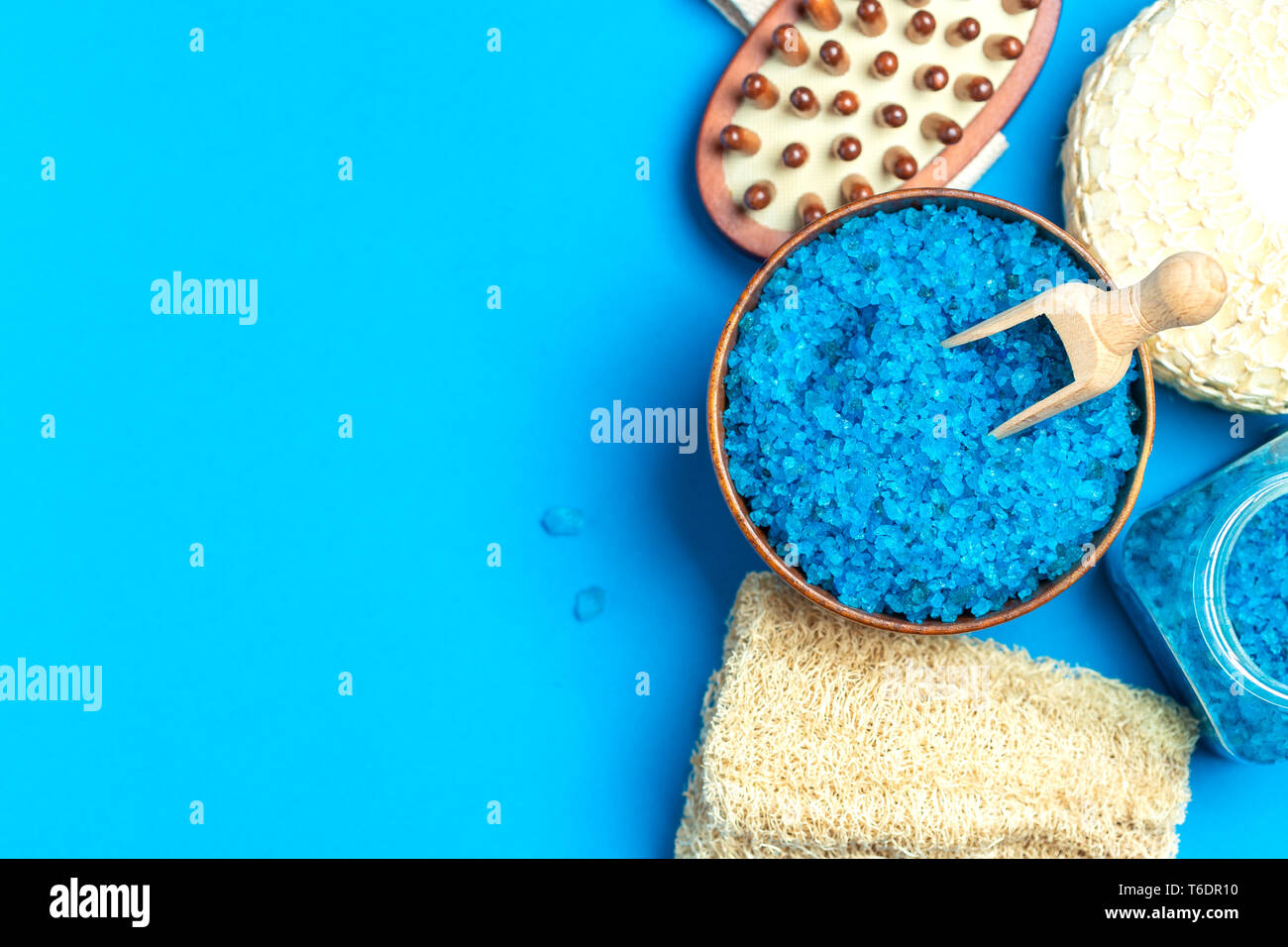 Spa setting with blue salt and sponge and copy space on blue background Stock Photo