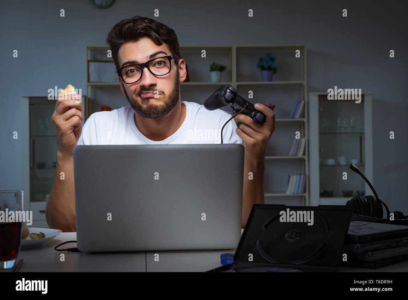 Young man playing games long hours late in the office Stock Photo Alamy