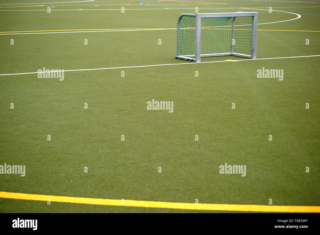 The close-up of an artificial turf field for football matches and field hockey with colored lines and color markings. Stock Photo