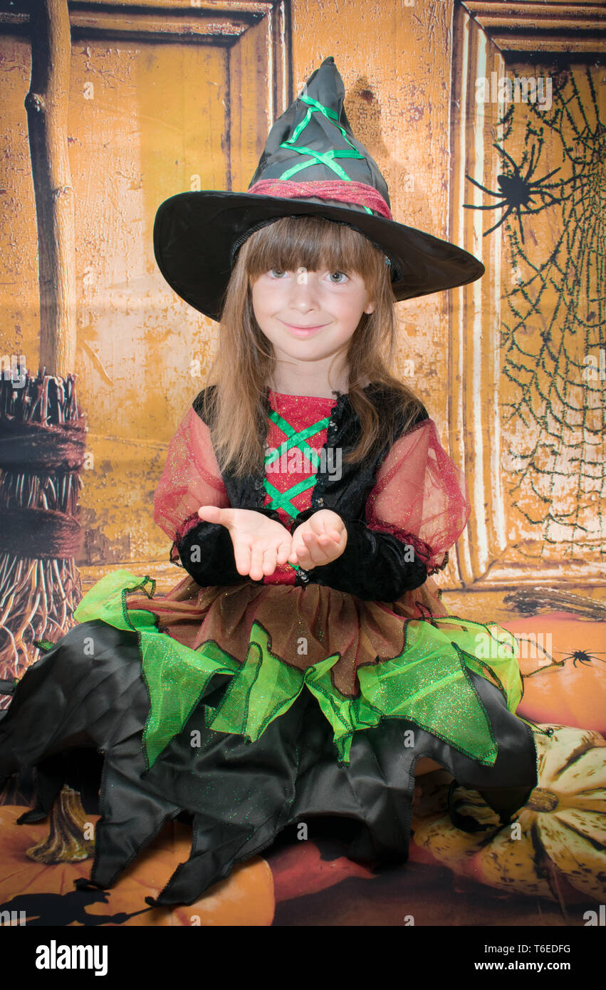 Little girl all dressed up for Halloween. On a Halloween background. Stock Photo