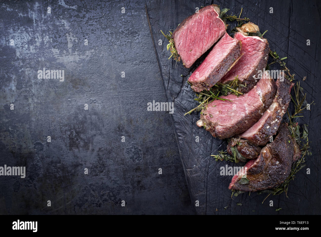 Kobe Ribs Barbecue dry aged Kobe rib eye steak as close-up on a burnt board with ...