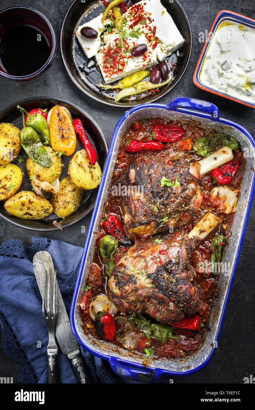 Greek roasted leg of lamb with feta and potatoes in tomato sauce as top