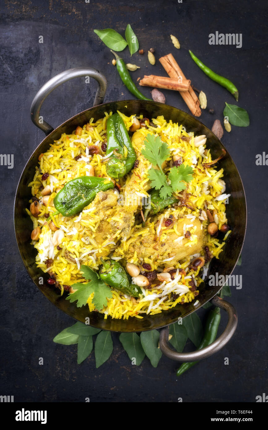 Indian chicken biryani with nuts and raisins as close-up in a korai ...