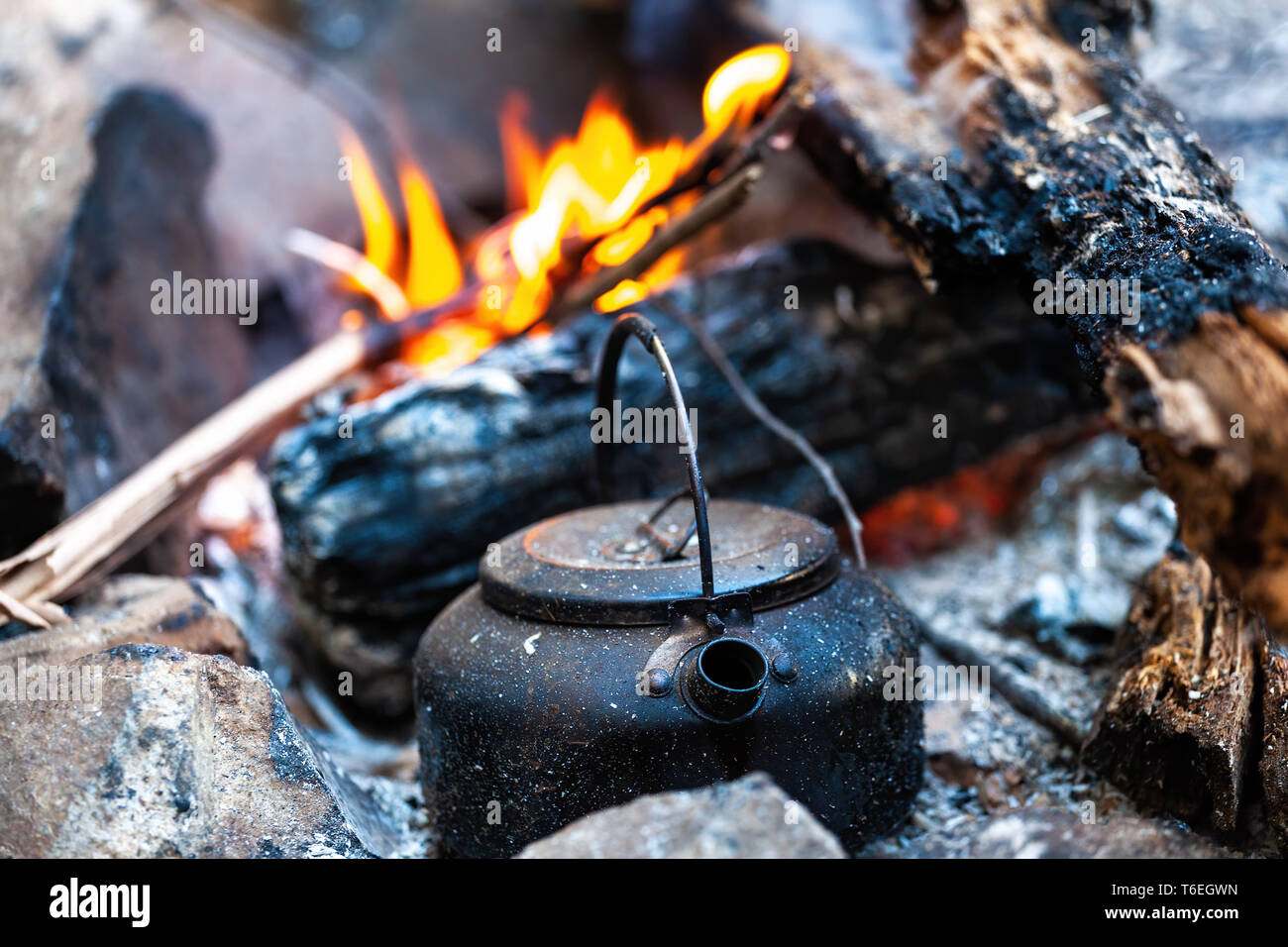Campfire kettle closeup with blurred bonfire in the background Stock Photo  - Alamy