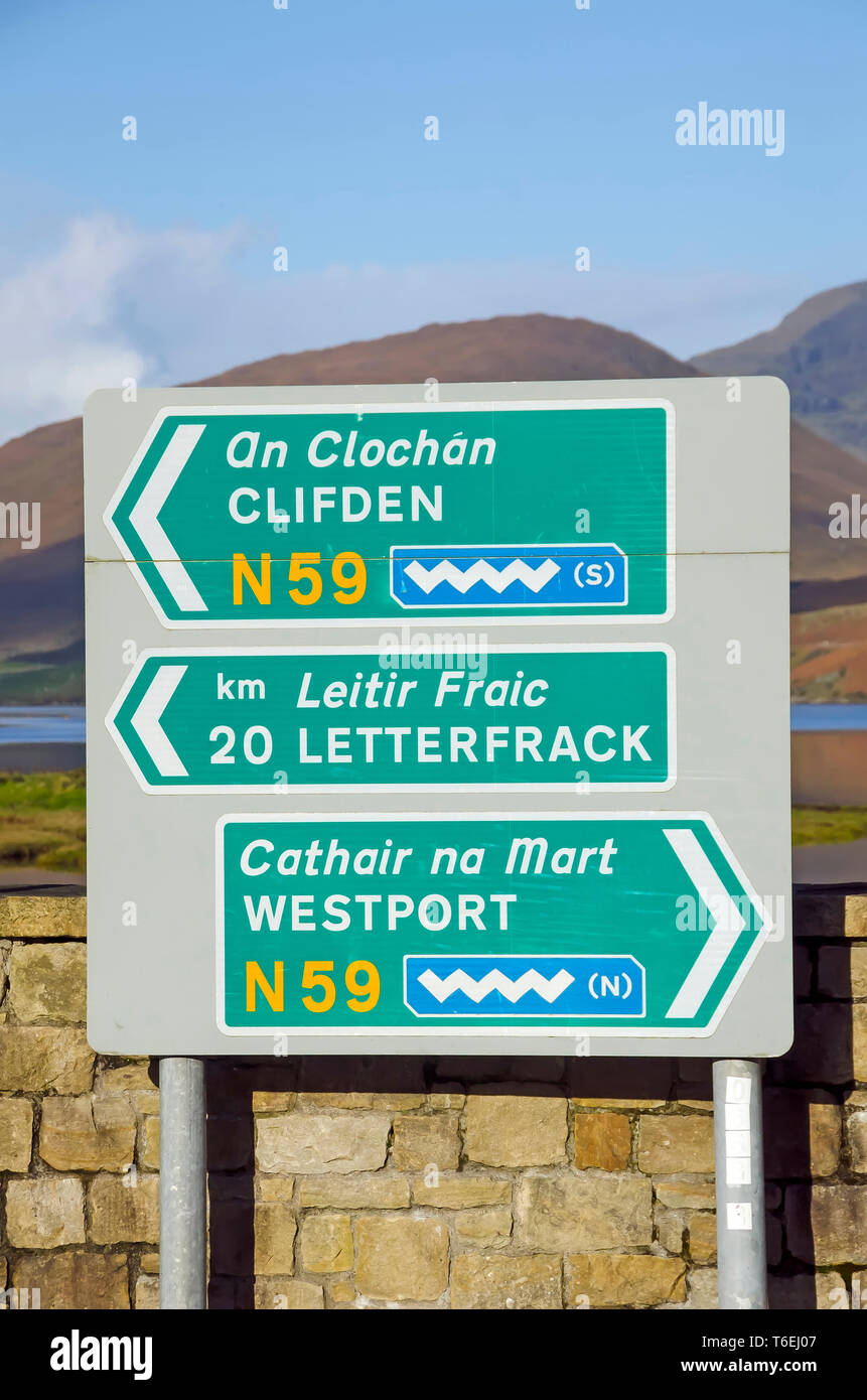 Bilingual road sign English and Irish Gaelic with Wild Atlantic Way tourist rotue  wave symbols   Galway Ireland Stock Photo