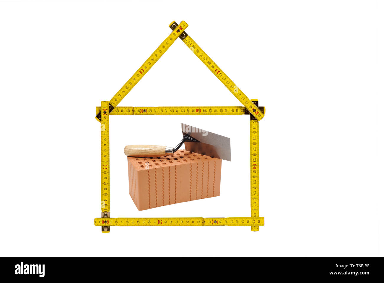 shell of house under construction with folding ruler in hand of real estate agent Stock Photo