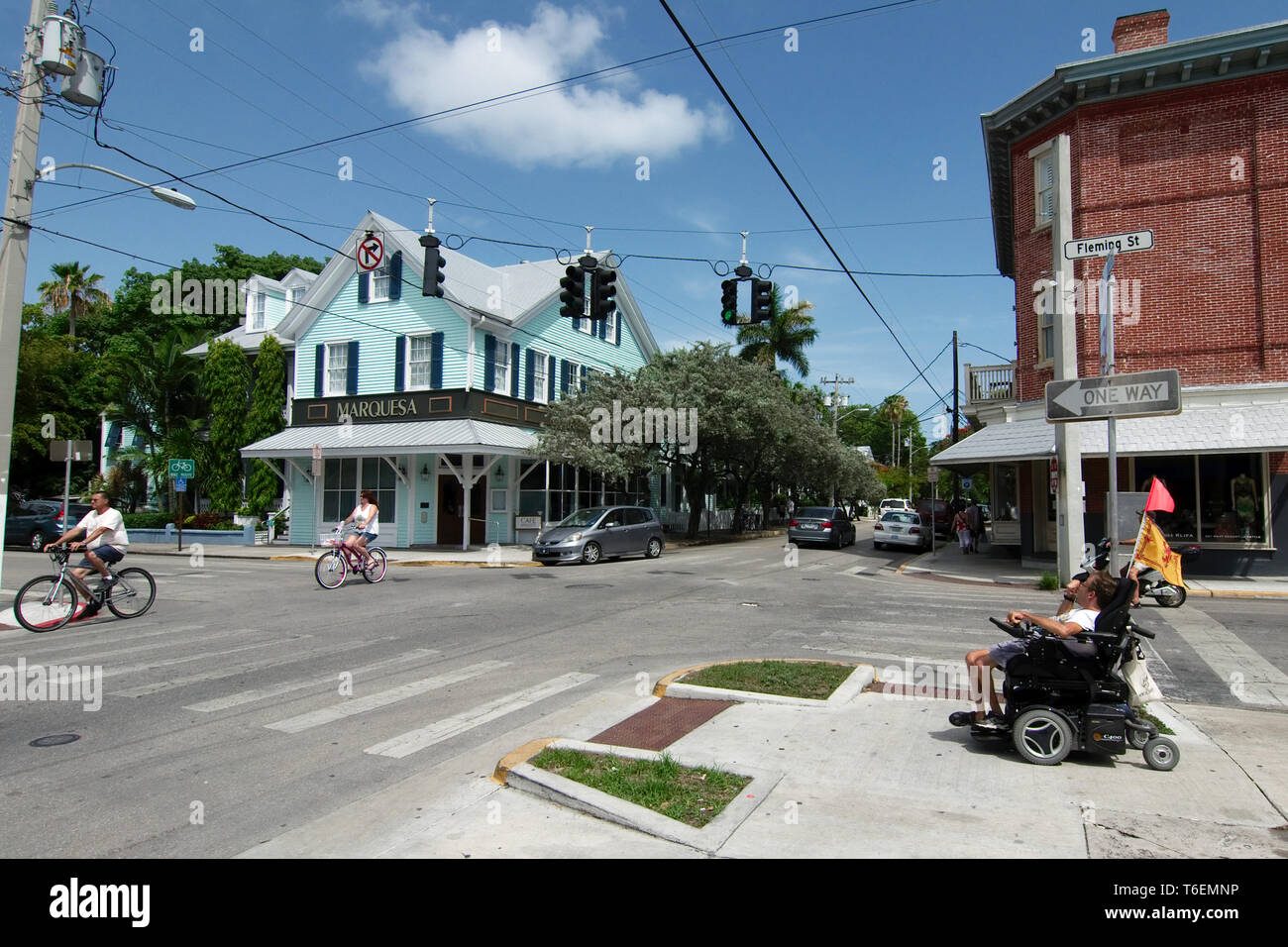 Key West, Florida, USA - 2019: People ride bicycles on a sunny day at the downtown district, as it is customary in this small touristic town. Stock Photo