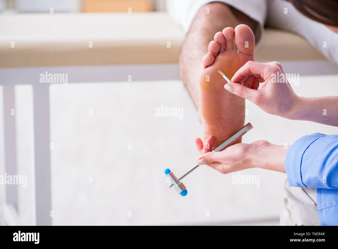 Doctor checking nerve reflexes with hammer Stock Photo Alamy