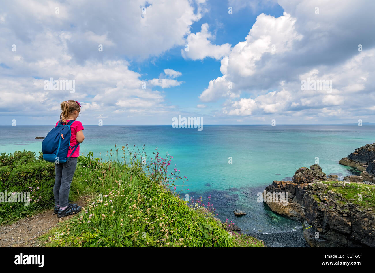 Girl with a backpack on the Cornish coast Stock Photo