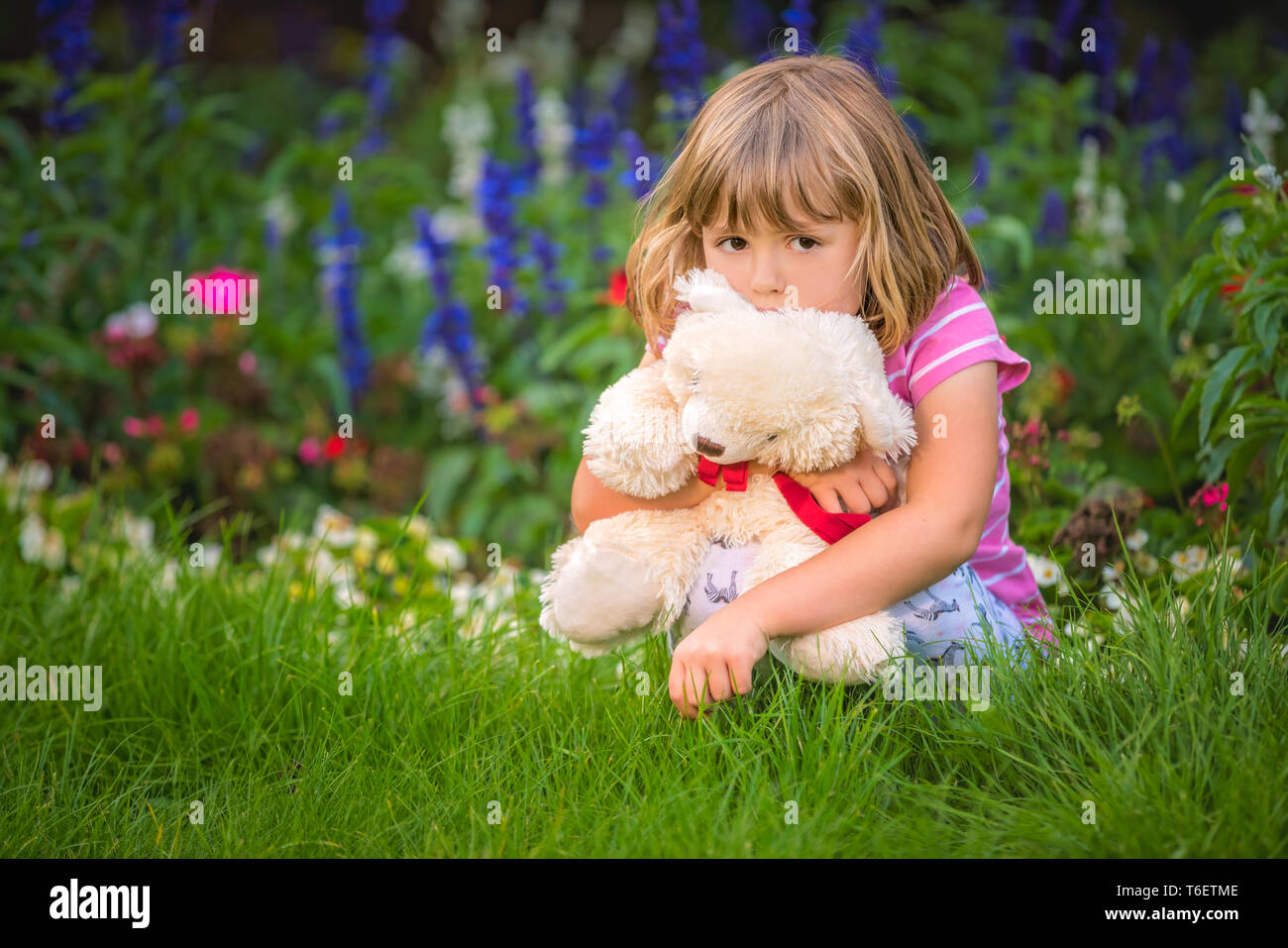 Adorable girl hugging her teddy bear in summer park Stock Photo - Alamy
