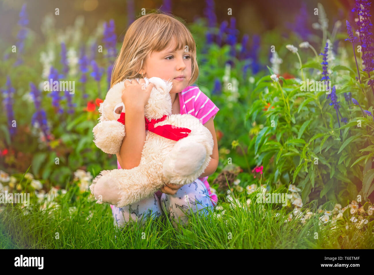 Adorable girl hugging her teddy bear in summer park Stock Photo - Alamy