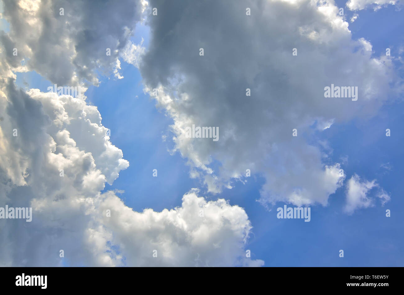 Blue sky background with fluffy cumulus white and gray clouds at sunlight backlit. Majestic heaven - meteorology or religious concept. Beauty and ener Stock Photo