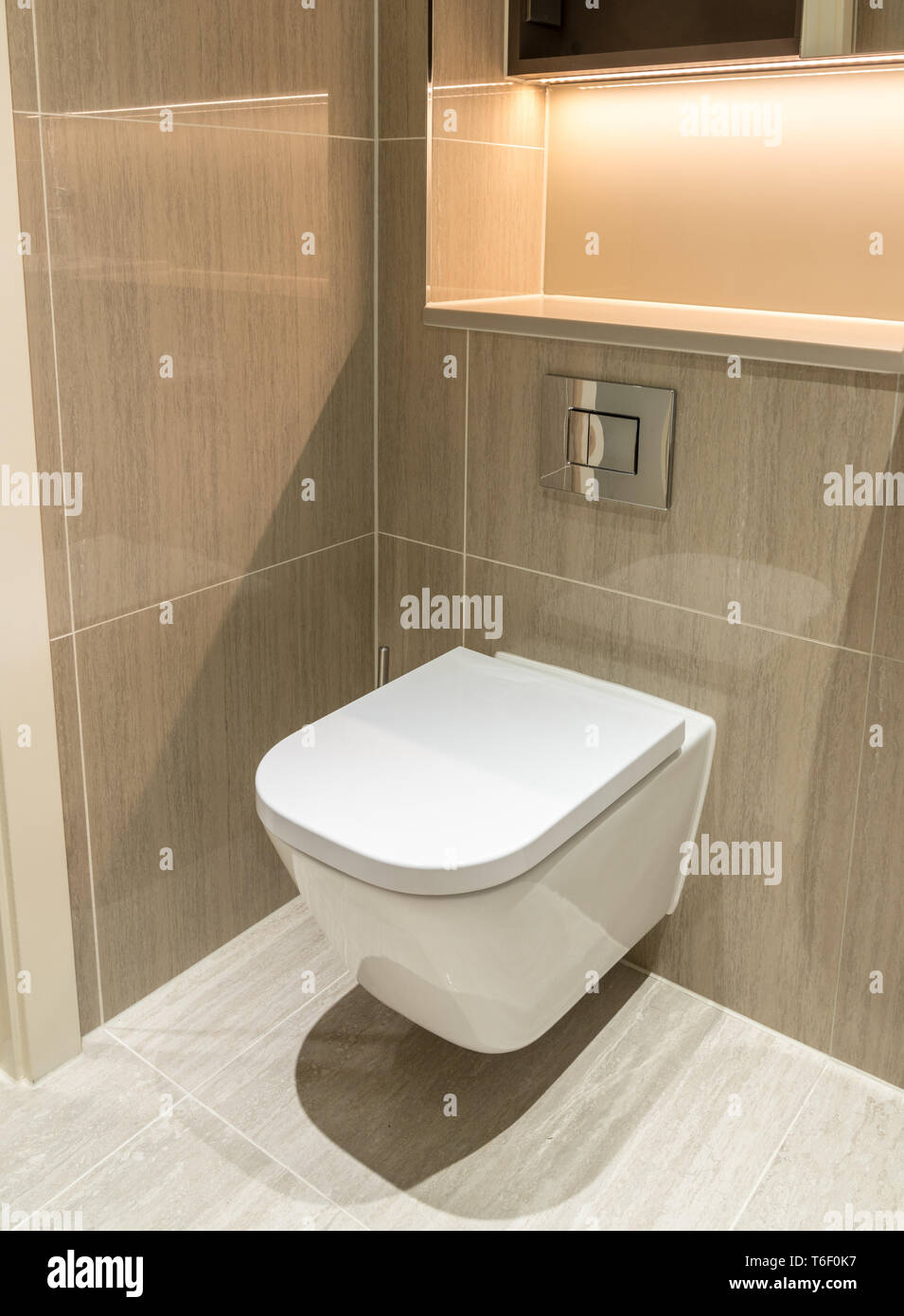 Modern toilet in flat or apartment suspended above tiled floor Stock Photo