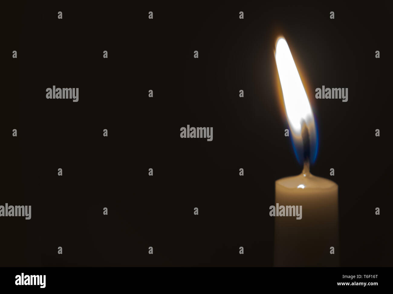 One light candle burning brightly in the black background Stock Photo