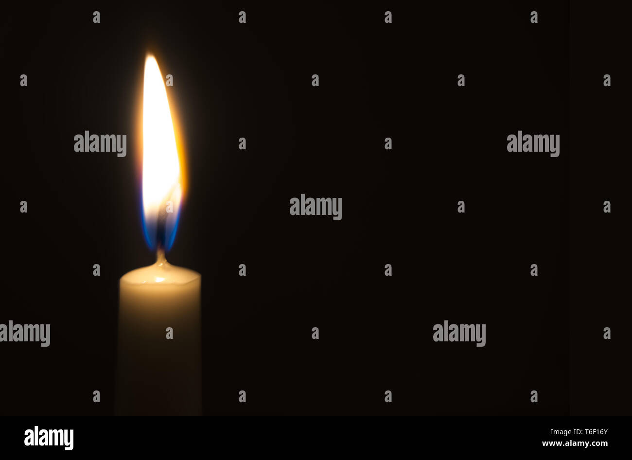 One light candle burning brightly in the black background Stock Photo