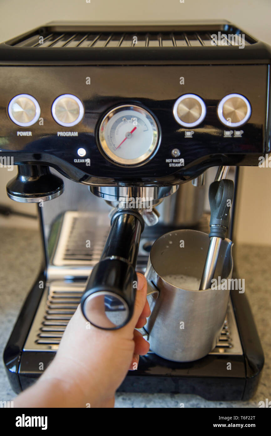 Steaming and frothing the milk for a flat white using a brushed steel