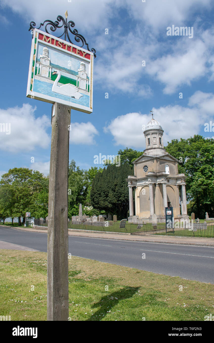 Village sign for Mistley Essex with Mistley towers in background Stock Photo