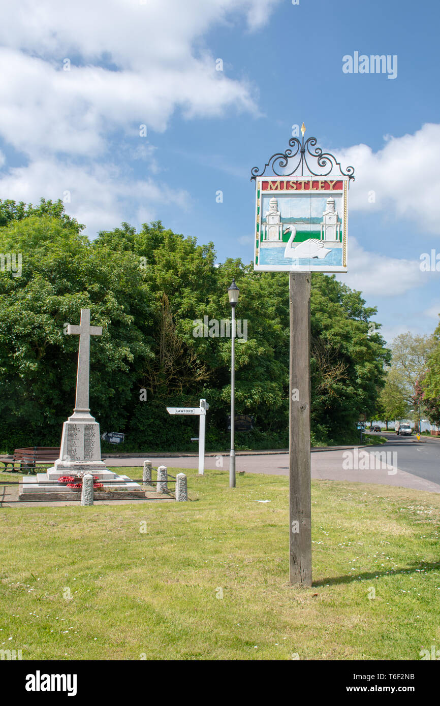 Village sign for Mistley Essex with memorial cross in background Stock Photo