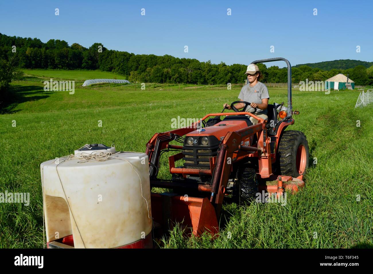 Hard working woman female farmer, fastest-growing group of farmers, moving water for pigs livestock with Kubota tractor, outside Decorah, Iowa, USA Stock Photo