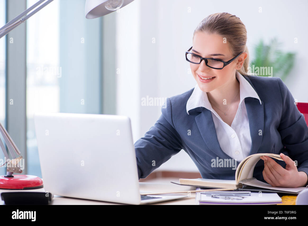 Businesswoman working at her desk in office Stock Photo - Alamy