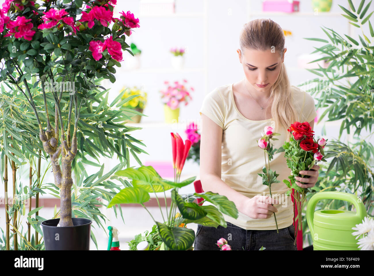 Young woman watering plants in her garden Stock Photo - Alamy