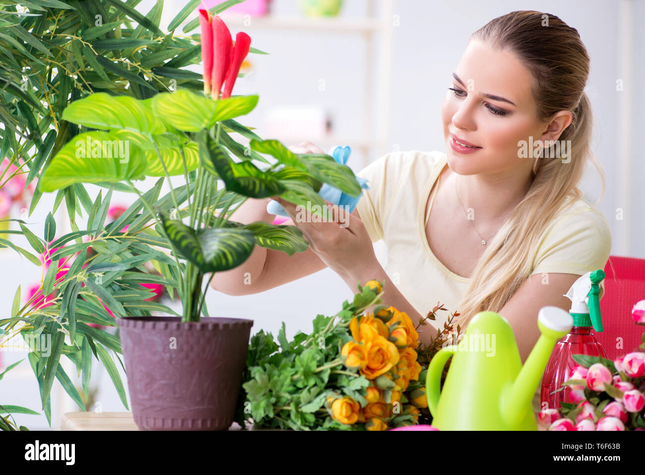 Young woman watering plants in her garden Stock Photo - Alamy