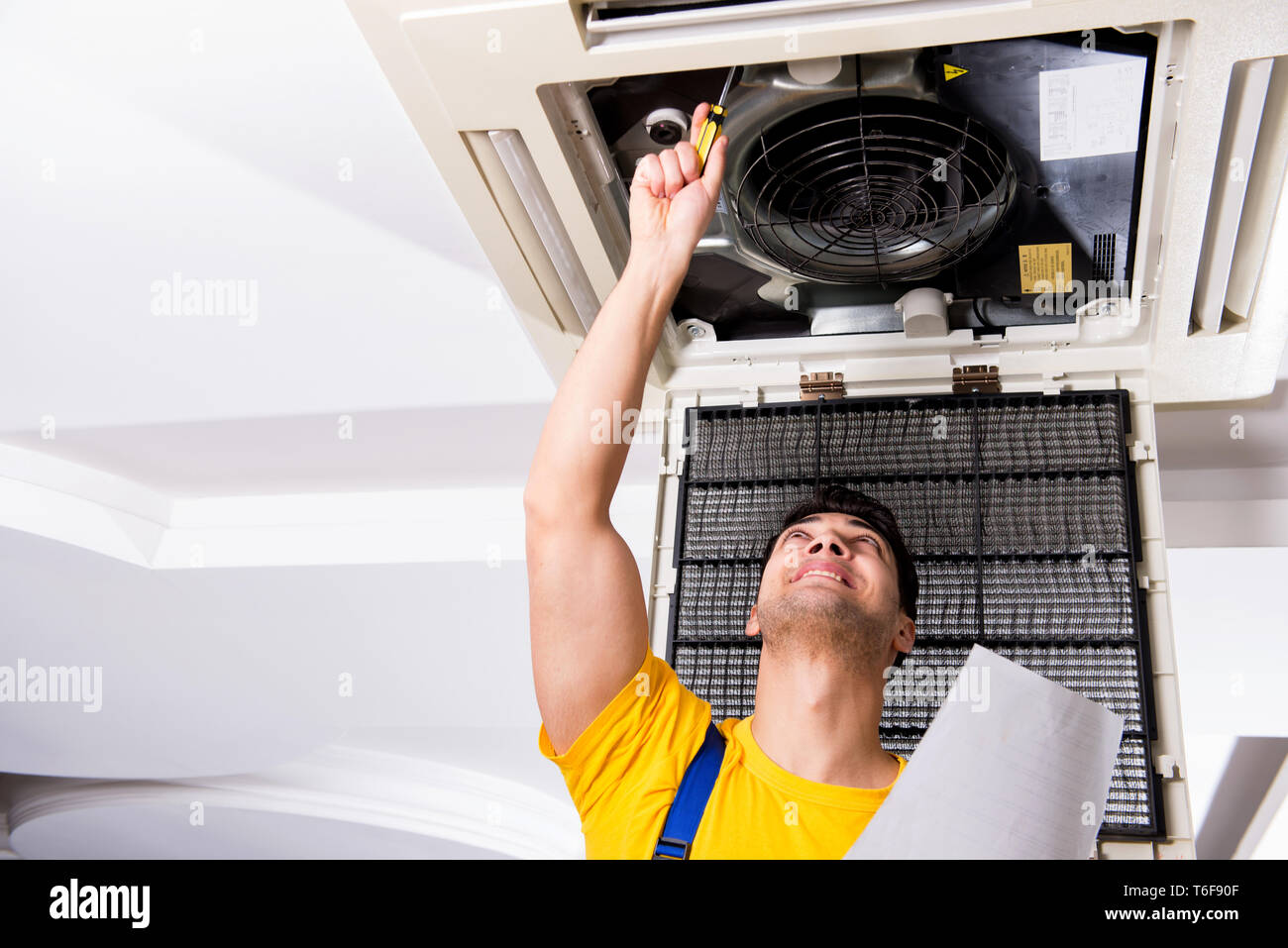 Repairman Repairing Ceiling Air Conditioning Unit Stock Photo