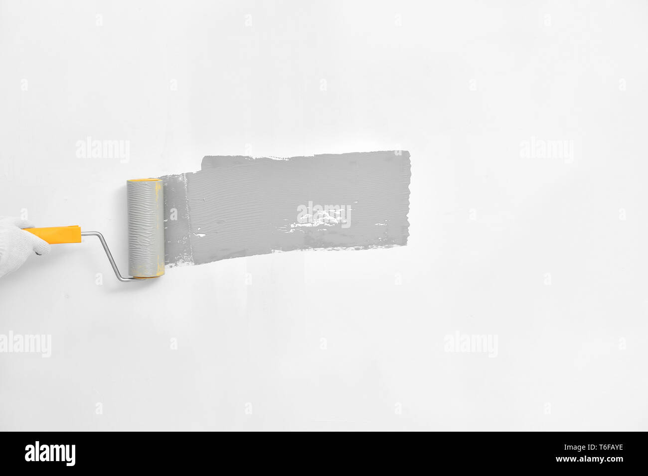 Painting white wall in grey color with roller brush Stock Photo Alamy