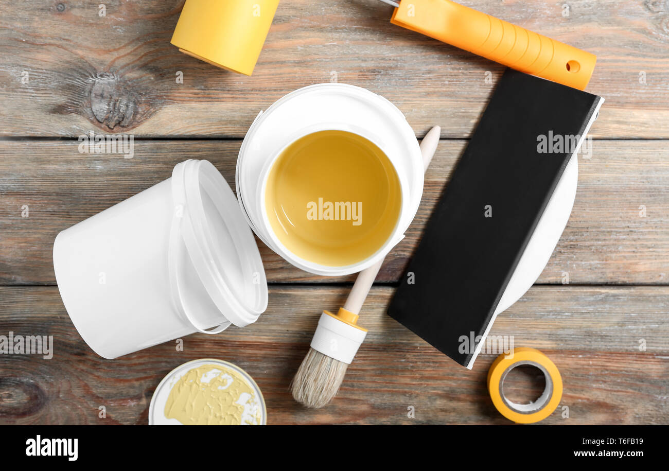 Paint cans and tools on wooden table Stock Photo
