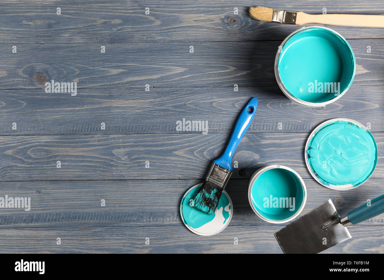 Paint cans and tools on wooden table Stock Photo