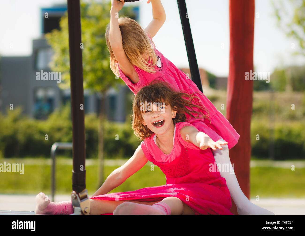 Two young girls playing happily on playground outdoor Stock Photo