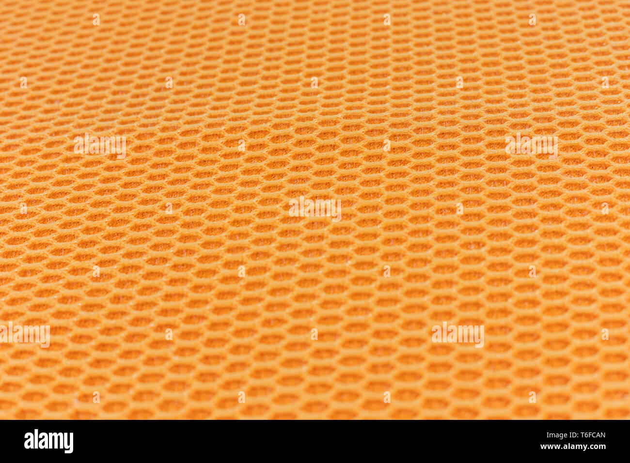 Honeycomb textured cloth flat lay, interesting hexagonal repeating pattern orange and yellow in colour Stock Photo
