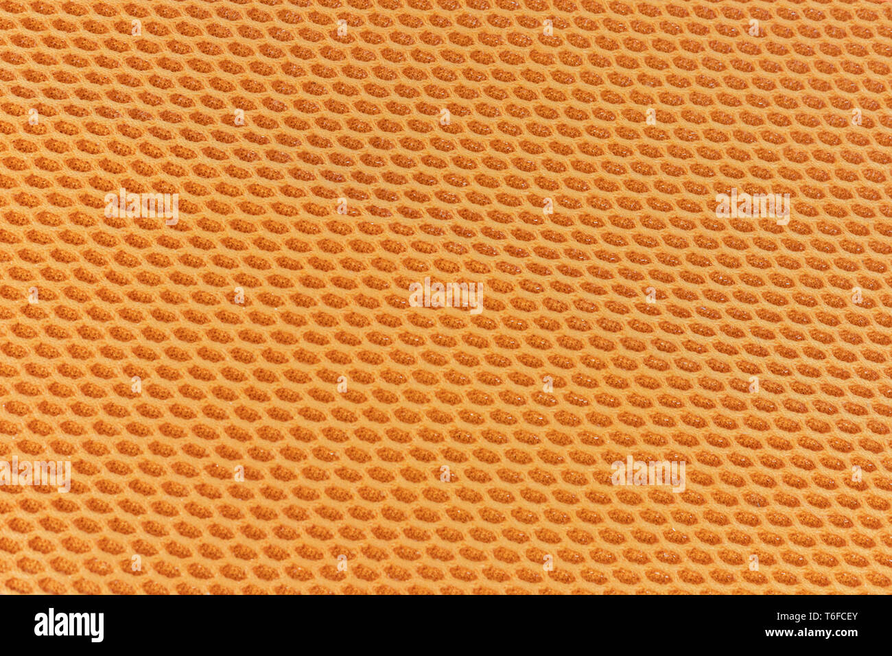 Honeycomb textured cloth flat lay, interesting hexagonal repeating pattern orange and yellow in colour Stock Photo