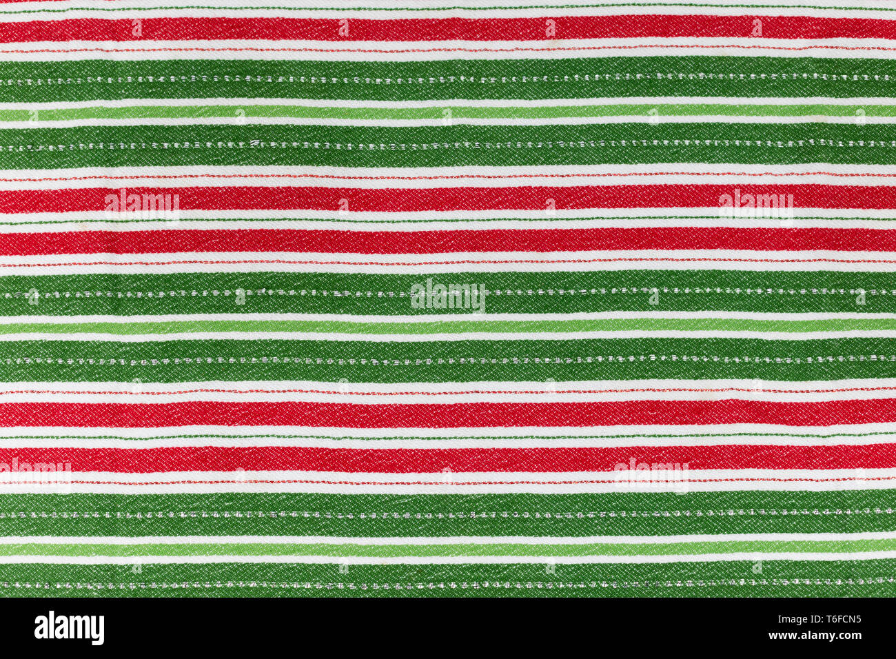 Red, white & green striped Christmas cloth laying flat for background
