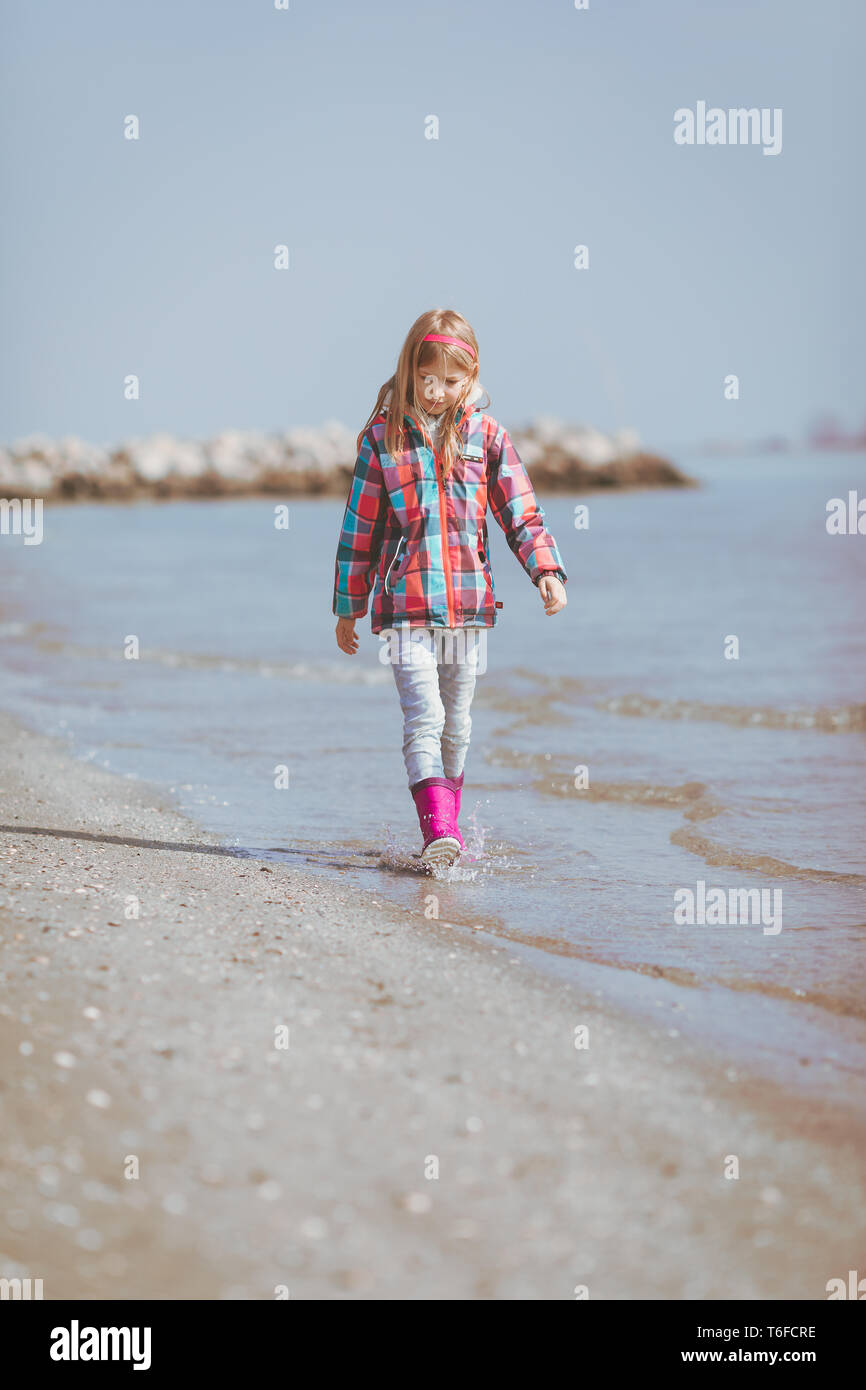 Young girl walking on a beach on a winter day Stock Photo