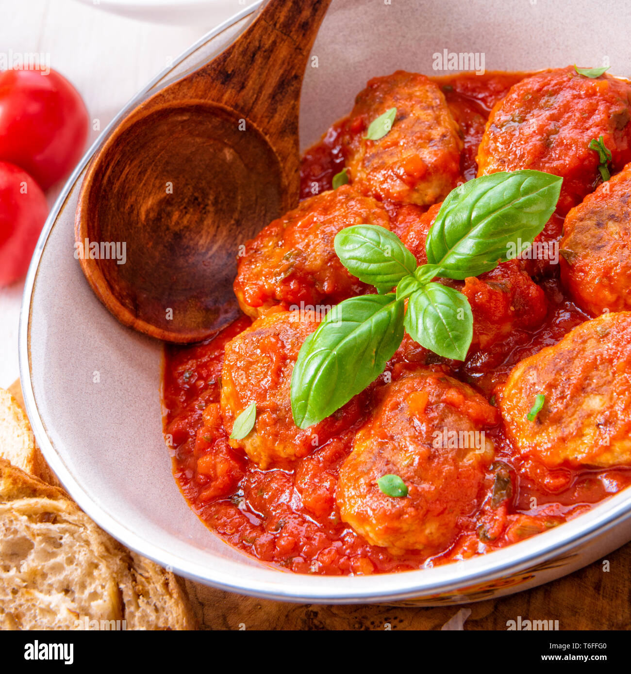Baked mini meatballs in tomato sauce with basil Stock Photo Alamy