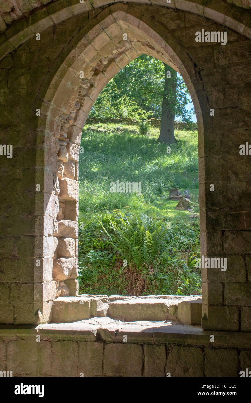 Looking through Norman ruined stone window to Countryside Stock Photo