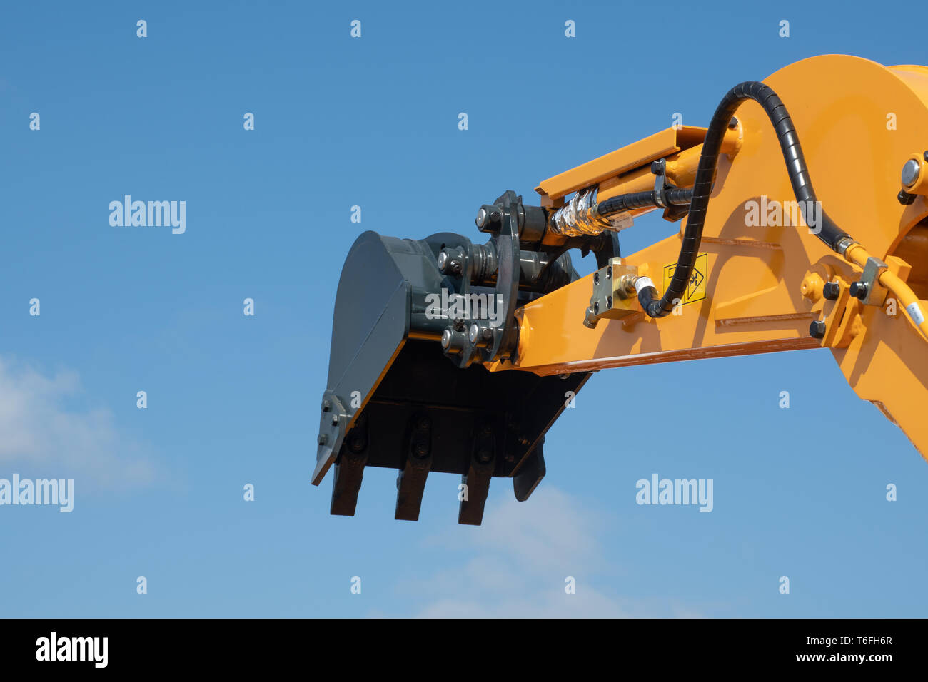 Arm of earth excavating equipment with blue sky Stock Photo