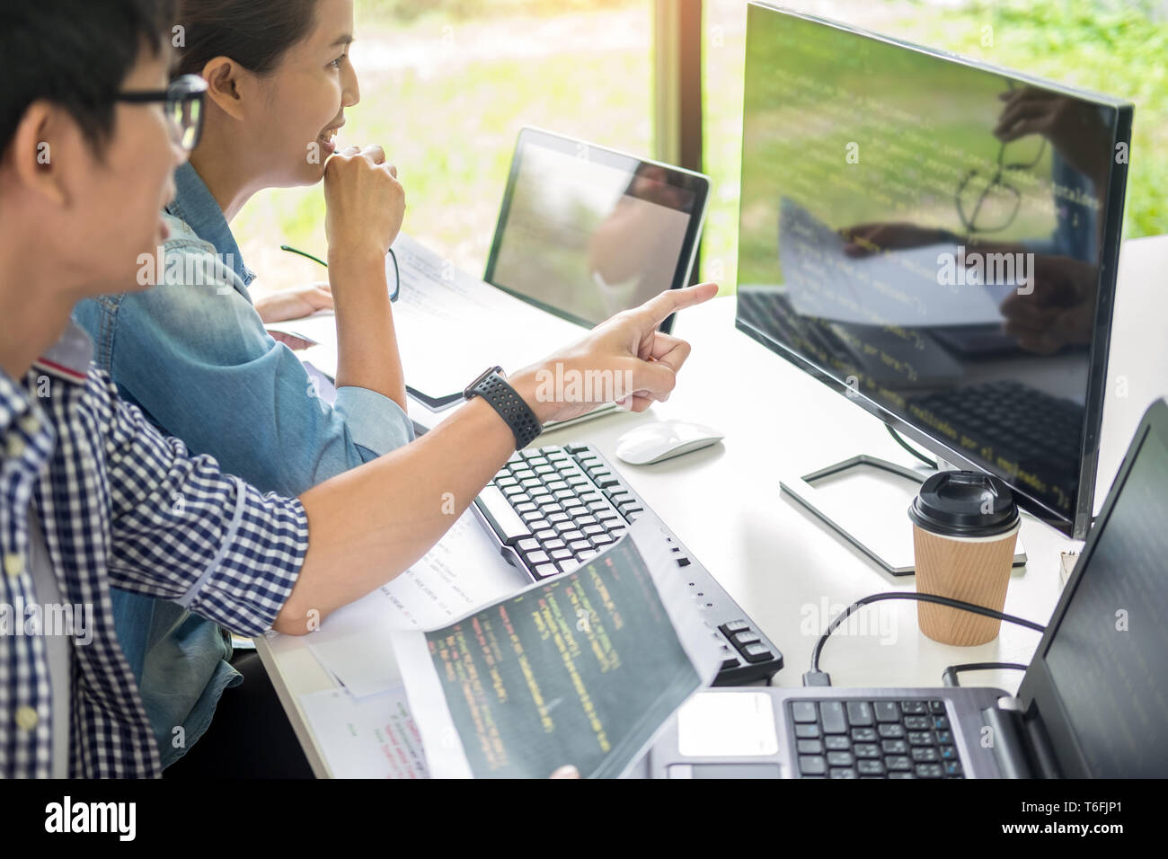 Asian team Outsource Developer Looking Screen Programming Code Working with Laptop Computer Software Stock Photo
