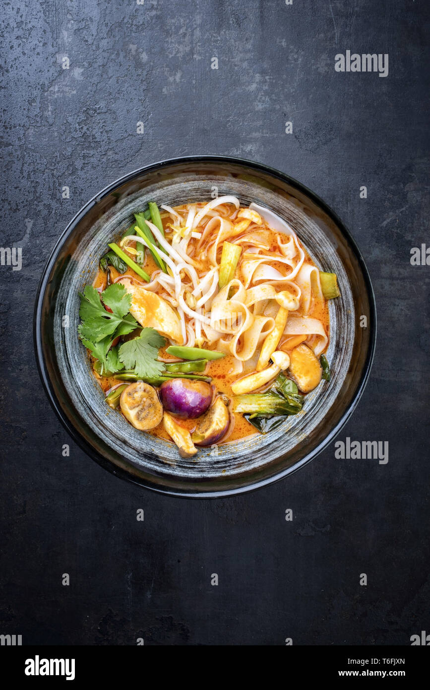 Traditional Thai kaeng phet red curry with vegetables and rice noodles as  top view in a wok Stock Photo - Alamy